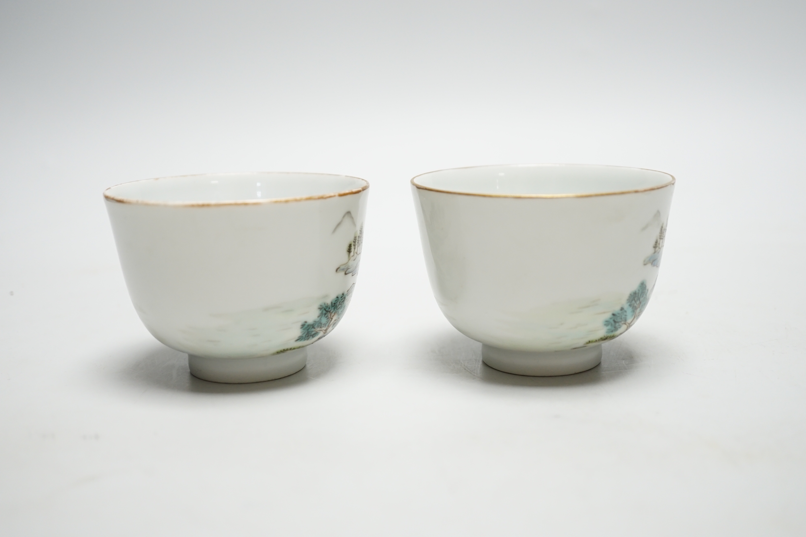 A pair of Chinese enamelled porcelain cups, landscapes and pagodas, 6cm tall
